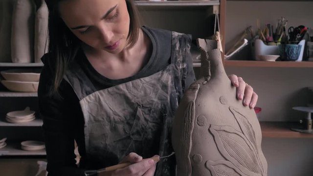 ceramist creates a pattern and relief dolly shot
