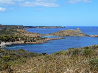 picture of the coast of the beautiful Menorca island in Spain. the mix of the green and blue colours of water and land create a beautiful natural effect. 
