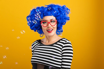 Fun portrait of pretty Asian woman with bright blue wig and red heart shaped glasses