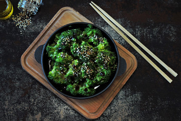 Baked broccoli with olive oil and sesame. Vegan lunch idea. Copy space.