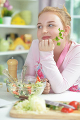 Close up portrait of cute teen girl preparing fresh salad