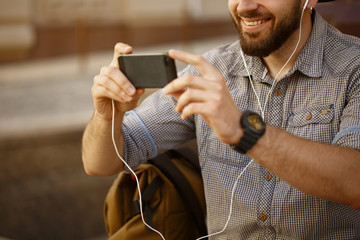 Young handsome bearded man using his smart phone