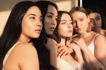 Obraz premium selective focus of five multicultural girls standing together in sunlight