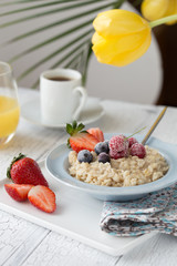 Breakfast oatmeal porridge with fruits berries and coffee cup. Oatmeal with strawberries and banana. Healthy breakfast concept.