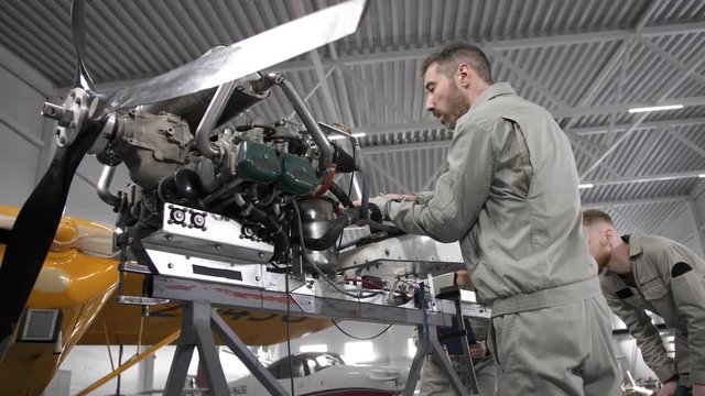 Specialists repairing aircraft engine