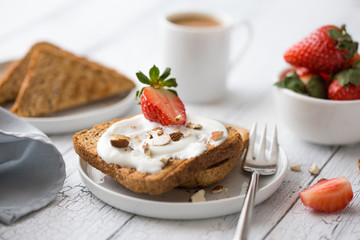 Soft cheese on toast. Cheese toast on the plate. Light Breakfast. Dill. The knife spreads the cheese on toasted bread. Soft butter on bread. Cooking toast.