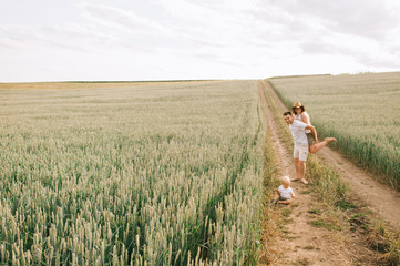 A young family have a fun with their little baby in the field