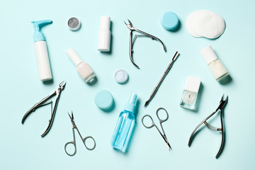 A set of cosmetic tools for manicure and pedicure on a blue background. Gel polishes, nail files and clippers, and the lamp top view  Place for text. Top view. Flat lay