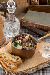 Summer cold soup okroshka with radish, cucumber and beef on wooden board