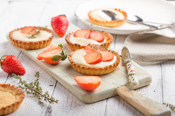   Save Download Preview Whole and slice of individual lemon curd tarts with strawberry  on a white rusty background. Flat lay and copy space.