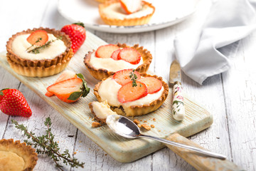   Save Download Preview Whole and slice of individual lemon curd tarts with strawberry  on a white rusty background. Flat lay and copy space.