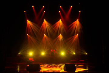 Lights beams on stage with musical instruments