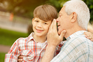Fototapeta premium Senior man whispering to his grandson