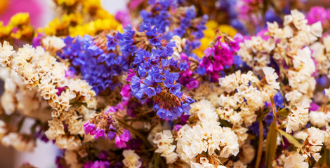 Bouquet of dry small white, blue and yellow flowers, background_