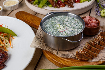 View from above of georgian cuisine on brown wooden table. Traditional georgian cuisine and food - khinkali, kharcho, chahokhbili, phali, lobio and local sauces - tkemali, satsebeli, adzhika. Top view