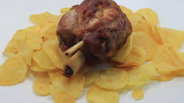 letto di patate con stinco di maiale arrostito