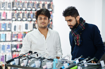 Two indians mans customer buyer at mobile phone store choose a selfie stick. South asian peoples and technologies concept. Cellphone shop.