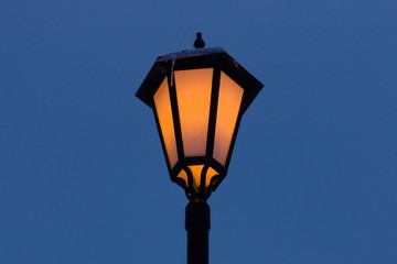 Fototapeta na wymiar Street vintage Lantern glows against the sky