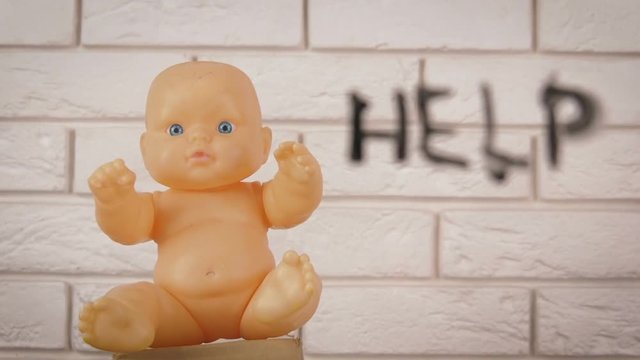Abortion. Unborn baby. Abortion concept - killing a child. A toy in the shape of a child asks for help.