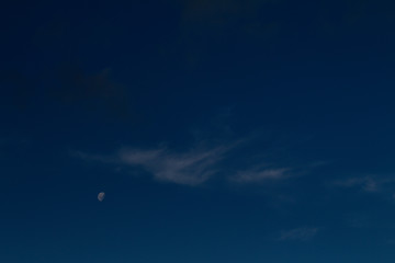 Obraz na płótnie Canvas Crescent moon, next to a small white cloud.