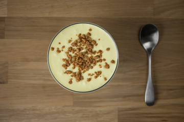 Mascarpone cream with biscuits on a wooden table from above