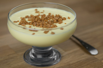 Close up of mascarpone cream with biscuits on a wooden table