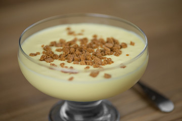 Close up of mascarpone cream with biscuits on a wooden table