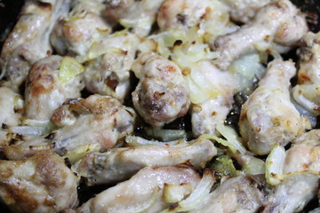 chicken fried with onions in a pan