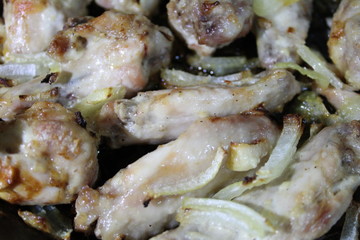 chicken fried with onions in a pan