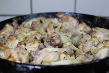 chicken fried with onions in a pan