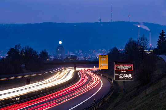 Germany, Stuttgart, Warning sign for particulate pollution alert and traffic in the evening