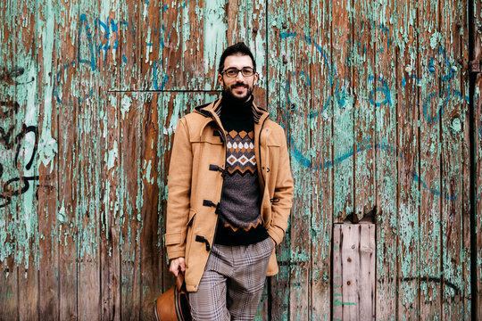 Spain, Igualada, portrait of smiling man standing at rundown wooden gate