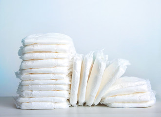 Stack of baby diapers on table. - obrazy, fototapety, plakaty
