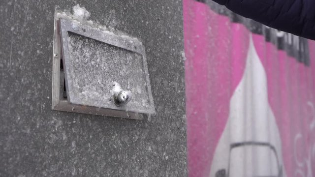 A man deposits money in a bill acceptor to pay for a car wash