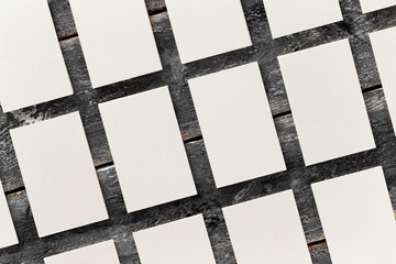 Flatlay mockup of white blank business cards rows at wooden vintage board background.