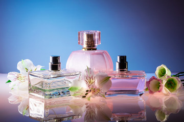 bright colored bottles of female perfume on a blue background