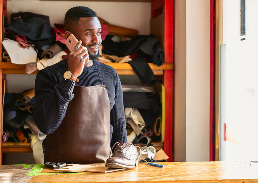 Shoemaker talking on the mobile phone in workshop - Powered by Adobe