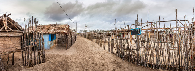 Fototapeta na wymiar View of a street with sand and wooden fences in Andavadoaka, Madagascar.