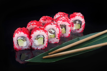 sushi roll with flying fish roe on black background