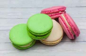 Multicolored macaroons on a wooden table, on a dark blue background, top view