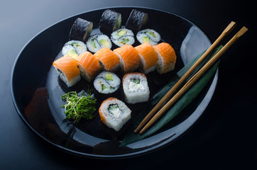 sushi set with different rolls on a black plate