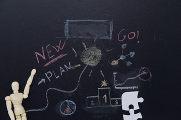  Wooden doll pointing to a blackboard, New ideas. Entrepreneurial concept, new ideas, innovation. Blackboard written with chalk