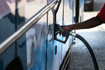 Male hand refuelling gasoline to a bus in Galle, Sri Lanka