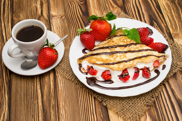 Crepes with Banana, Chocolate and strawberries with cup of coffee.