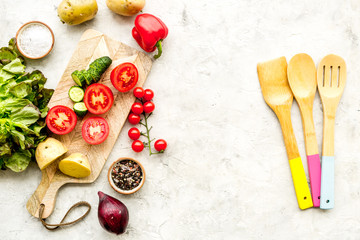Fresh organic vegetables for healthy food cooking on light stone background top view