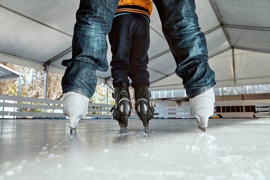 Grandfather and grandson on the ice rink, ice skating