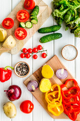 cooking with raw vegetables on white wooden background top view