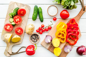 Obraz na płótnie Canvas Fresh food ingredients for vegetarian kitchen on white wooden background top view