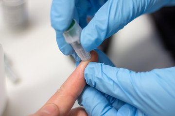 Diabetes patient measuring glucose level blood test using ultra mini glucometer and small drop of...