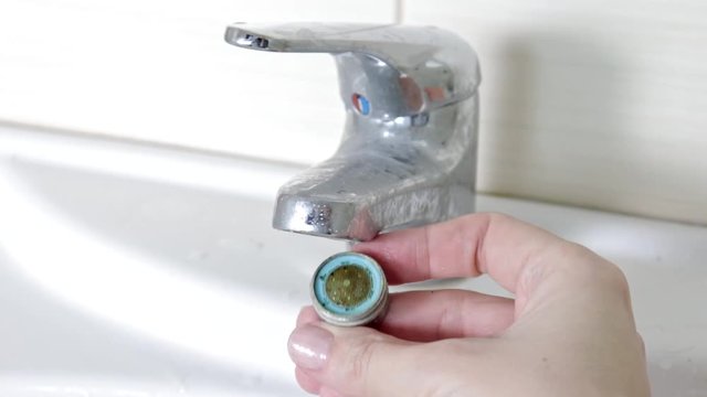 Woman handyman replace tap aerator, hands of a plumber close-up